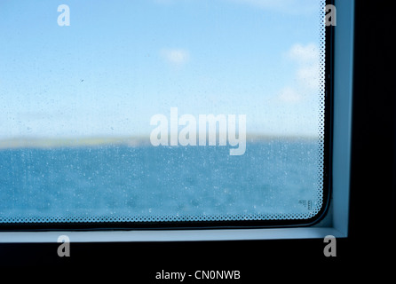 Eine verschwommene Sicht auf den Meerblick aus dem Fenster eine Personenfähre in Schottland Stockfoto