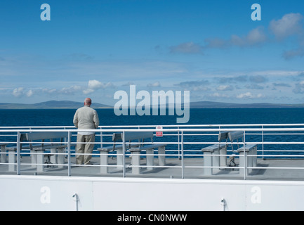 Ein einsamer Mann steht auf dem Oberdeck eine Personenfähre über den Pentland Firth an einem Sonnentag schottischen Segeln. Stockfoto