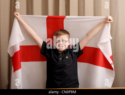 Ein 12 Jahre alter Junge lächelt, während die englische Flagge hoch halten Stockfoto