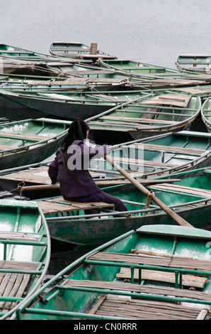 Tam Quoc Ruderboote nebeneinander im Hafen. Eine Person kümmern sich um Boot. Eine Person Rudern. Stockfoto