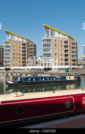 Lastkähne vor modernen Apartments auf Limehouse Bassin, Tower Hamlets, London, England. Stockfoto