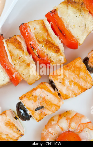 Nahaufnahme von gegrillten Lachs und Garnelen mit Tomaten und Paprika auf Bambusstäbchen Stockfoto