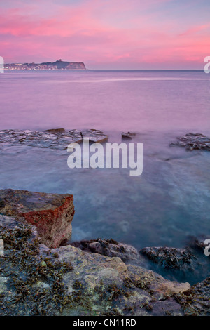 Breaking Dawn über Scarborough Castle Landspitze und einen eingehenden Flut, mit Blick nach Norden über die Nordsee von einer rockpool in Carneol Bay Stockfoto