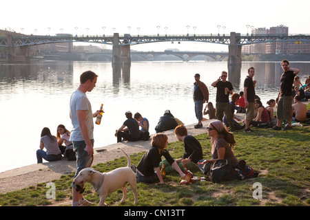 Junge Franzosen in The Port De La Daurade, entlang der Promenade Henri Martin mit Blick auf Pont St. Pierre, Toulouse, Frankreich Stockfoto