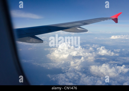 Wolken und Flügel während des Fluges durch Flugzeugfenster gesehen. Stockfoto