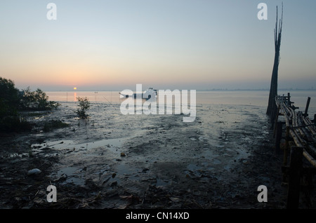 Ärgern Sie Boot bei Sonnenaufgang und Ebbe in Labutta Hafen aus der Ferne gesehen. Irrawaddy-Delta. Myanmar. Stockfoto