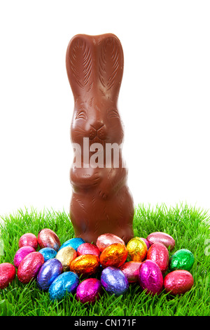 Schokolade Osterhasen und bunten Eiern auf Rasen auf weißem Hintergrund Stockfoto