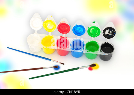 Satz von Tempera-Farben und Pinsel auf farbigen Hintergrund Stockfoto