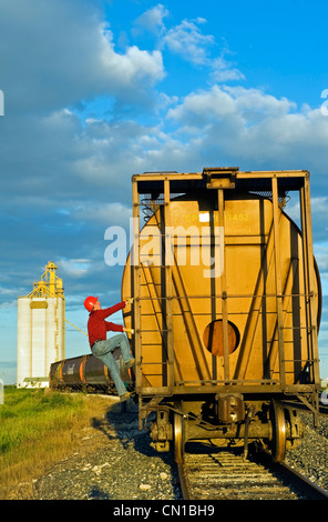 Wahl des Künstlers: Arbeiter klettert eine Korn-Waggon-Trichter an eine im inland Getreideterminal, Manitoba Stockfoto