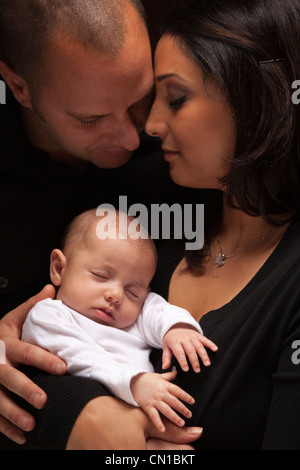 Glückliche junge attraktive Mischlinge Familie mit Neugeborenen. Stockfoto