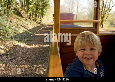 Glücklich kleiner Junge reitet auf einem Schmalspur Zug - die Rudyard Dampfeisenbahn in Staffordshire, UK Stockfoto