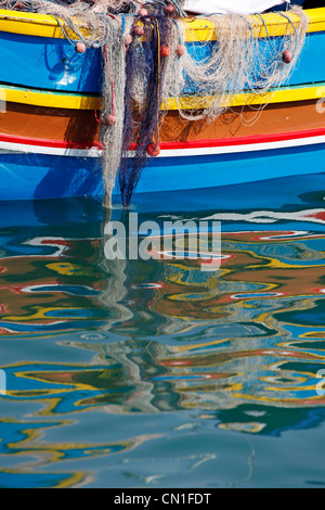 Fischernetze auf einer traditionellen maltesischen Angelboote/Fischerboote, bekannt als Dghajsa im Hafen von Marsaxlokk, Malta Stockfoto