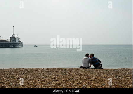 Ein paar küssen sich am Strand von Brighton Stockfoto