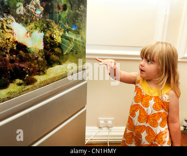 Junges Mädchen sucht einen Fisch In Salzwasser Aquarium Fische zeigen Stockfoto