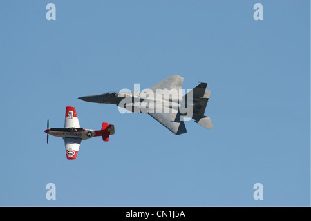 P51D Mustang und F15 Strike Eagle im Formationsflug mit einem strahlend blauen Himmelshintergrund. Stockfoto