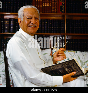 Saudi Arabien Alter Mann mit Schnurrbart hält Buch & Gläser Stockfoto