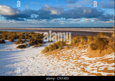Schnee bedeckt die Dünen und Strand von Holkham Bay an der Küste von Norfolk im winter Stockfoto