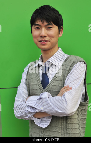 asiatische Geschäftsmann an die Wand gelehnt Stockfoto