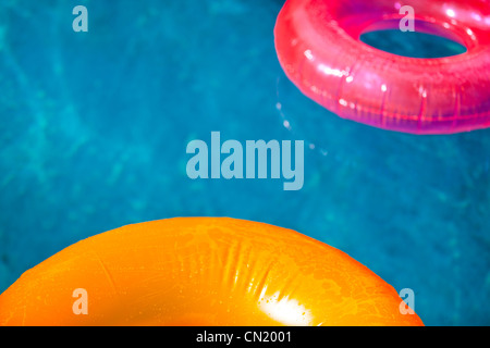 Schwimmendes aufblasbares Spielzeug auf dem Pool im Sommer beleuchtet von der warmen Sonne Stockfoto