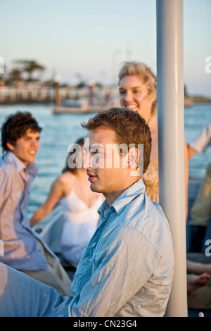 Zwei junge Paare, die entspannend auf Segelboot Stockfoto