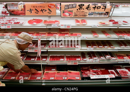 Ein Mitarbeiter Aktien Regale mit Packs vom Wagyu-Rind an einem Seitenarm des Uny Supermarkt in Nagoya, Japan. Stockfoto