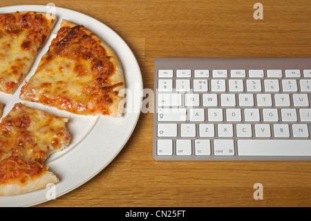 Hausgemachte Pizza neben Computer-Tastatur Stockfoto