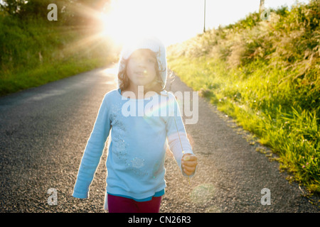 Mädchen, die Landstraße hinunter Stockfoto