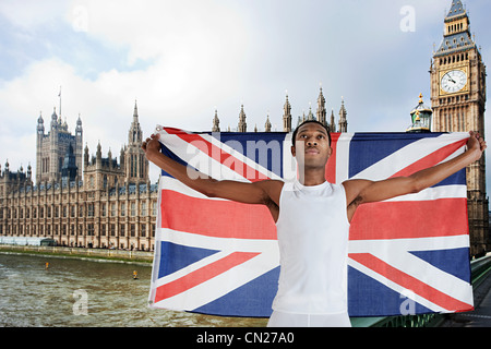 Olympische Konkurrenten mit Union Jack vor Houses of Parliament, London, England Stockfoto
