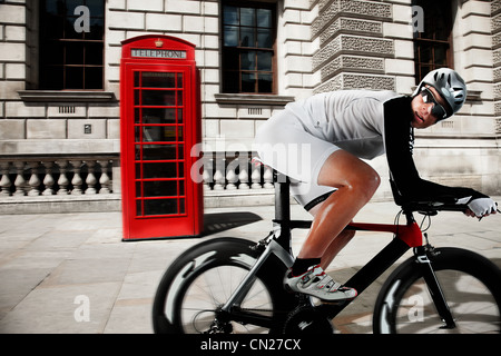 Vorbei an roten Telefonzelle Radfahren Radfahrer Stockfoto