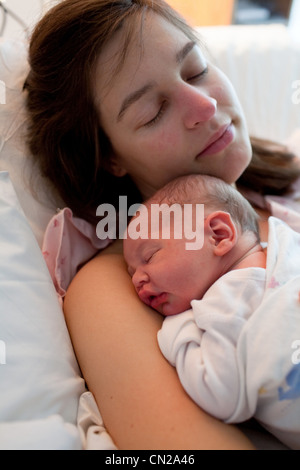 Mutter und Neugeborenes Babyjungen schlafen im Krankenhausbett Stockfoto