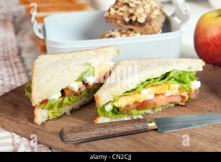 Kunststoff Lunchbox mit Sandwiches auf einem Holzbrett Stockfoto