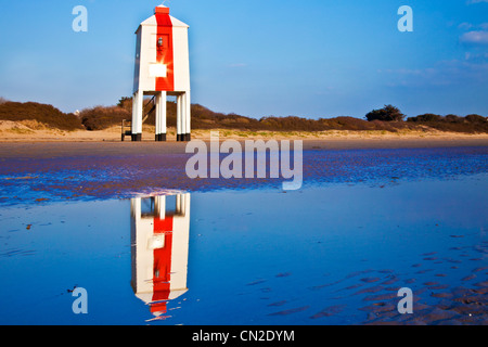 Der ungewöhnliche Leuchtturm auf Stelzen an Burnham-on-Sea, Somerset, England, UK spiegelt sich in ein Gezeitenbecken Stockfoto