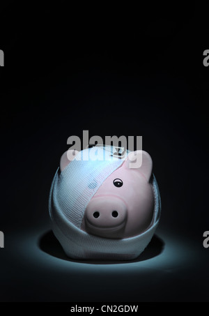 BANDAGIERTE VERLETZTEN SPARSCHWEIN MIT SICHERHEIT PIN WIEDER EINSPARUNGEN DER WIRTSCHAFT FINANZKRISE CREDIT CRUNCH ZINSSÄTZE MÄRKTEN BARGELD UK Stockfoto