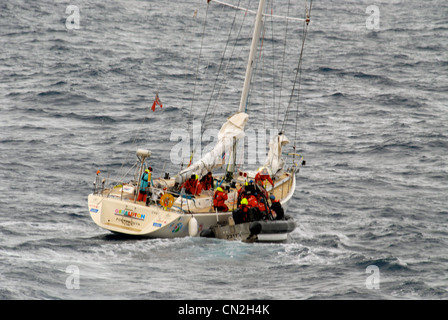 Crew des Cutter-Bootes der Küstenwache Bertholfs arbeitet daran, 2 verletzte Crew von einer beschädigten Rennyacht 250 Meilen westlich der kalifornischen Küste, 2. April 2012, zu erholen. Zwei Matrosen wurden verletzt, nachdem eine große Welle Berichten zufolge das 68-Fuß Geraldton Western Australia etwa 400 Meilen westlich der kalifornischen Küste, 1. April 2012, getroffen hatte. Es folgten mehr als zwei Tage intensiver Such- und Rettungseinsätze, die von der Küstenwache, dem 129. Rettungsflügel der Air National Guard und einem AMVER-Schiff gemeinsam durchgeführt wurden. Stockfoto