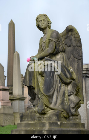 Die Statue des Engels, mit eine künstliche Blume in der Hand ruht auf einem Denkmal in Glasgow Necropolis. Stockfoto