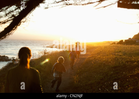 Familie zu Fuß durch die Küste bei Sonnenuntergang Stockfoto