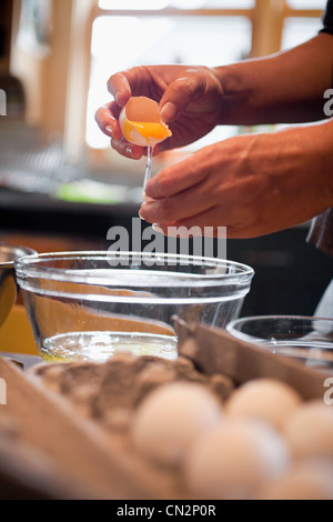 Person knacken Ei in Schüssel Stockfoto