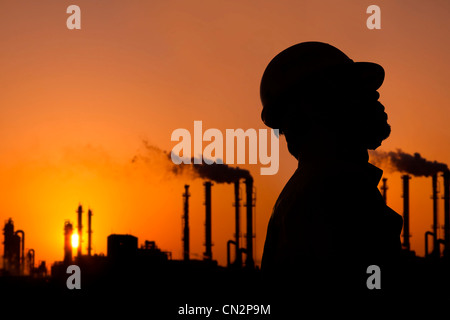 die Silhouette des Öl-Raffinerie Arbeitnehmer bei Sonnenuntergang Stockfoto