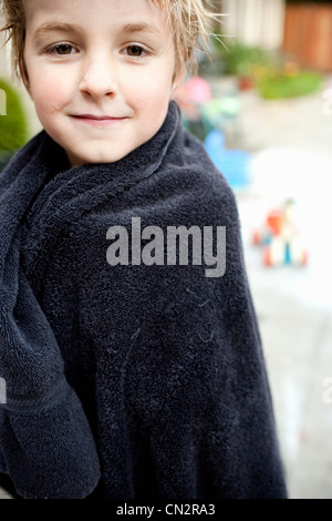 Kleiner Junge in Blick in die Kamera Handtuch gewickelt Stockfoto