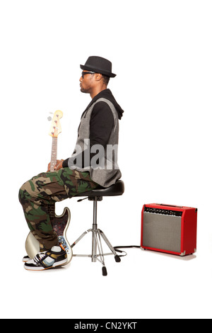 Mann sitzt auf einem Hocker mit e-Gitarre Stockfoto