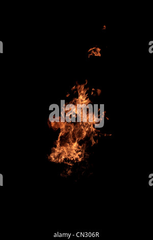 Flamme des Feuers, die isoliert auf schwarz - echtes Foto Stockfoto