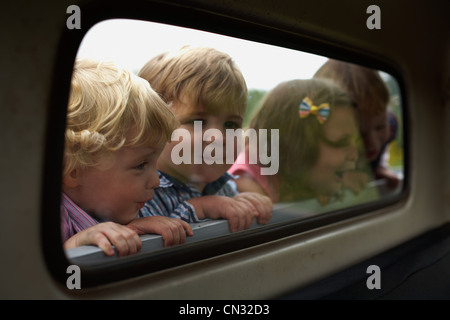 Vier Kinder spähte durch LKW-Fenster Stockfoto