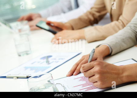 Nahaufnahme der Ablagen mit Business-Grafiken und Diagrammen, die mit ihnen verbunden Stockfoto