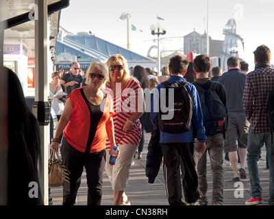 Menschen, die auf einem belebten Brighton Pier flanieren Stockfoto