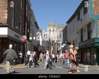 Menschen Touristen Besucher in der Innenstadt und West Towers of The Minster Low Petergate York North Yorkshire England Vereinigtes Königreich Großbritannien GB Großbritannien Stockfoto