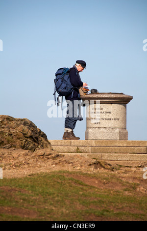 Reifer Mann am Gipfel Stein des Leuchtfeuers im Gedenken an Königin Victoria Herrschaft 1897 in den Malvern Hills im April Stockfoto