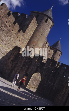 Zwei Menschen, die zu Fuß unter die Mauern und Türme der mittelalterlichen Stadt Carcassonne, Frankreich Stockfoto