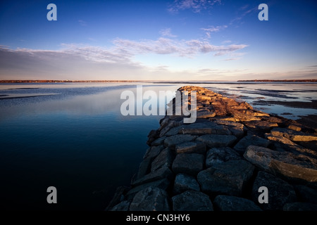 Ein steinerner Steg erreicht auf den Horizont auf dem ruhigen Wasser des Ottawa River in der Nähe von Britannia Strand im frühen Morgenlicht. Stockfoto