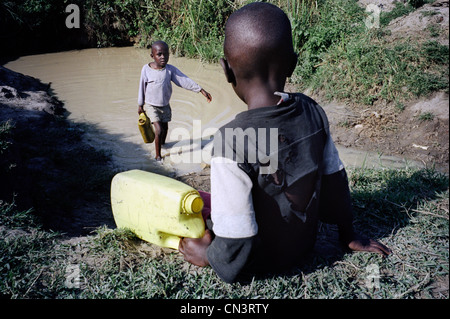 Afrikanischen jungen Wassertragen vom Wasserloch Stockfoto