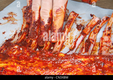Rieb Marinade über Spareribs Stockfoto